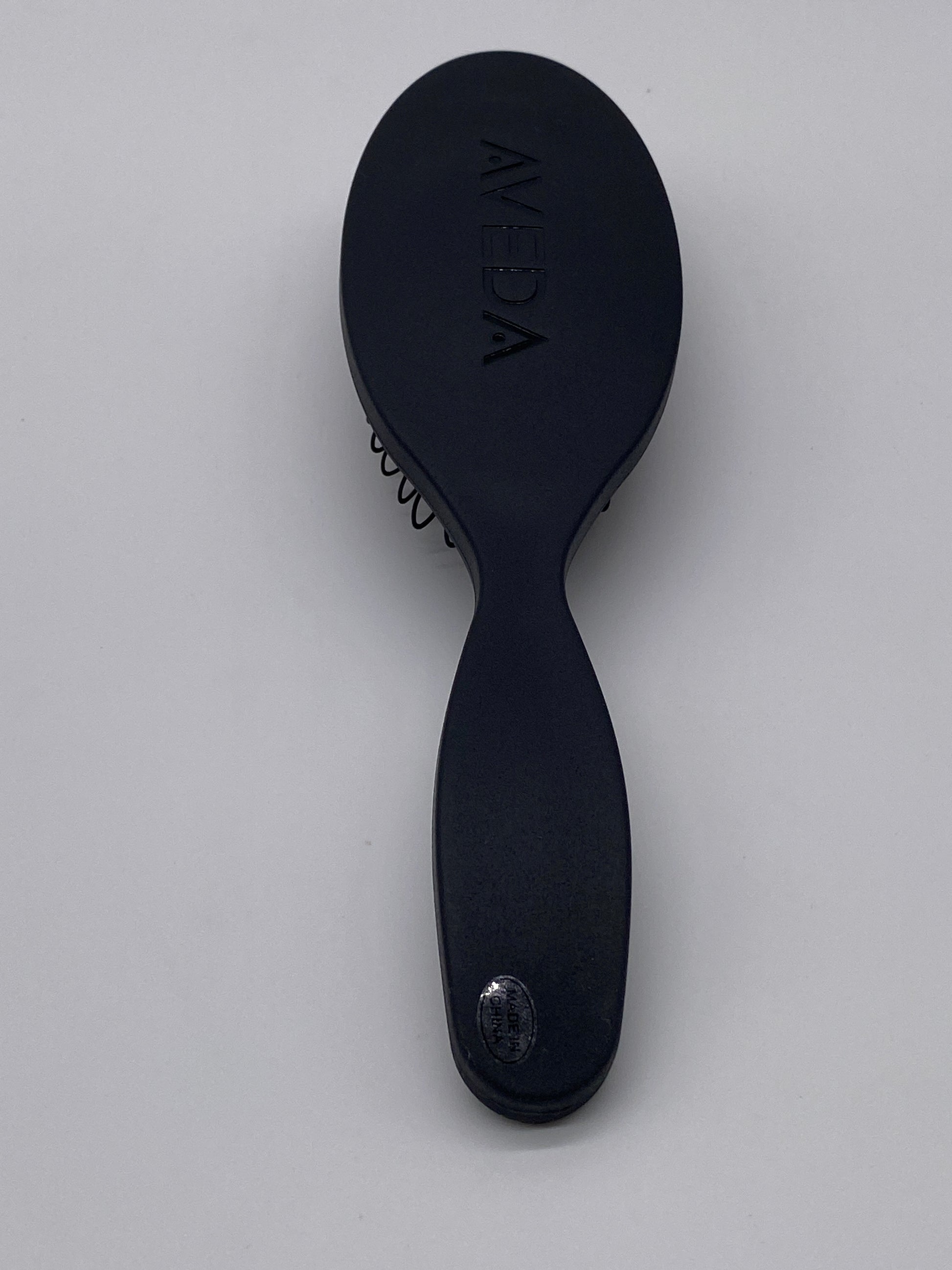 Aveda Pramasana Exfoliating Scalp Brush on white background.